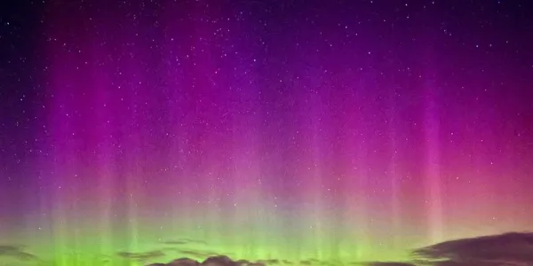 Aurora Borealis sky in a purple colour fading to a light green.