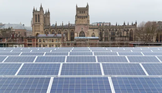 An array of solar panels, with Bristol Cathedral behind them