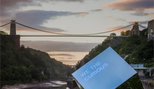 Clifton Suspension bridge with a large shiny cube reading 'We The Curious' in the foreground