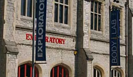 A stone building with red doors and signs reading 'Exploratory'