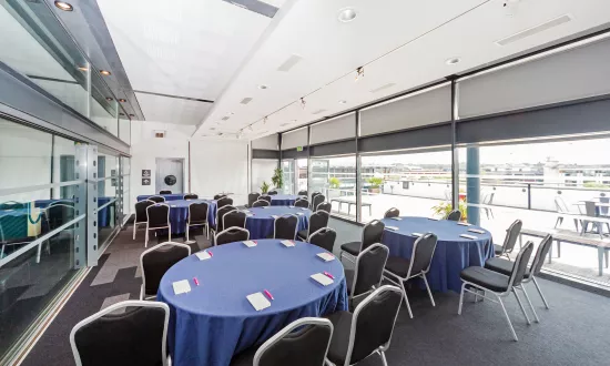 A room filled with round tables and chairs placed around them