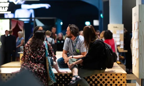 A group of adults sitting casually in the Theatre of Curiosity in the We The Curious venue