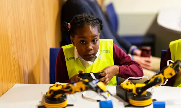 A child playing with a robot in an education workshop