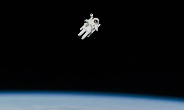 An astronaut floating in space with the Earth below