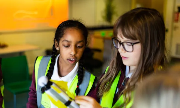 Two children investigating a rocket in an educational workshop at we the curious