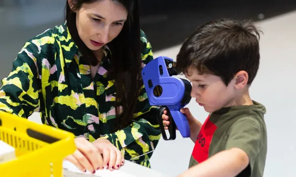 A person and a child playing make pretend shop