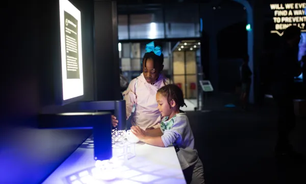 Two children getting curious with an interactive exhibit about light and shadow 