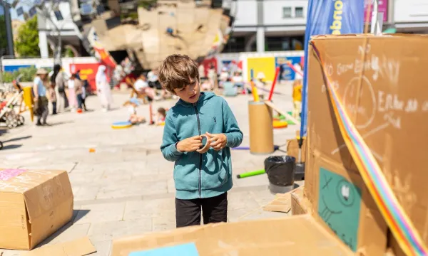 Child building items with cardboard on Millennium Square