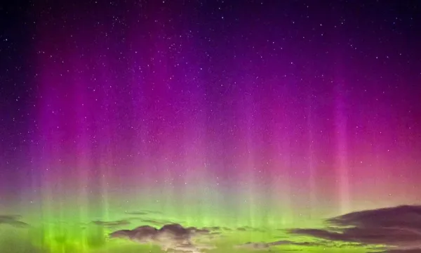 Aurora Borealis sky in a purple colour fading to a light green.