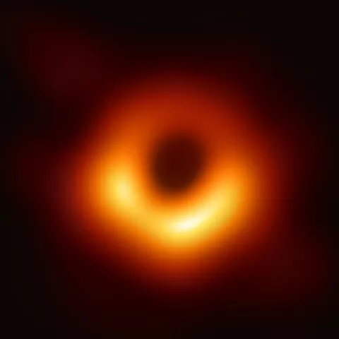 Bright donut shape of orange light on a black background.