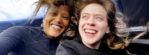 A photo of two space explorers. On the left, Sian H. Proctor. On the right, Hayley Arceneaux. Both are smiling