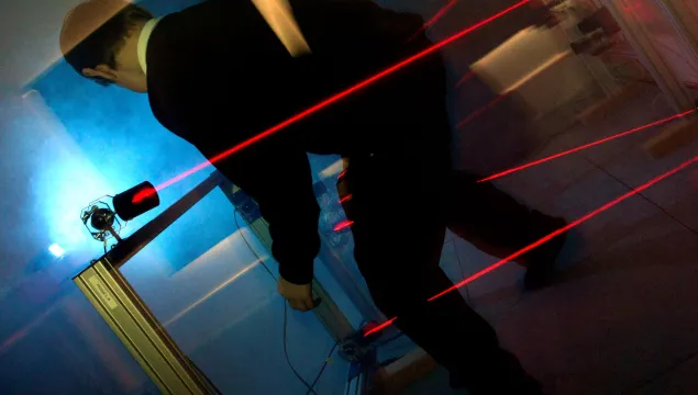 A child going through a laser maze 