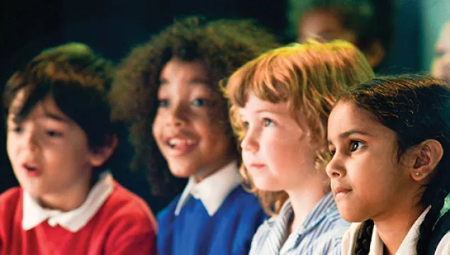 Eager looking bright eyed students looking at a science show smiling 