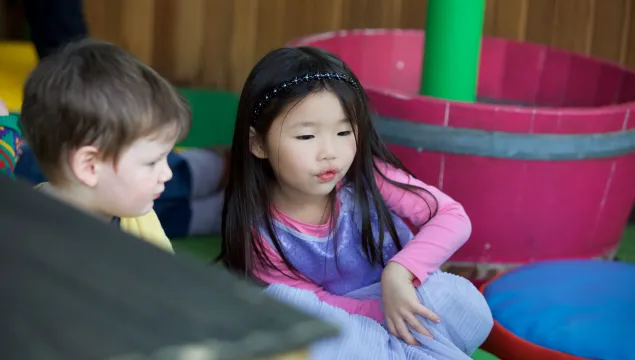 Two small children are playing in a science centre.