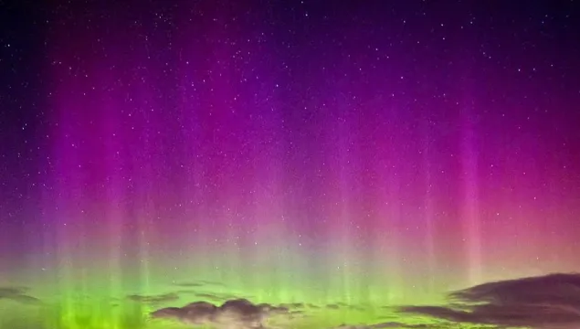Aurora Borealis sky in a purple colour fading to a light green.
