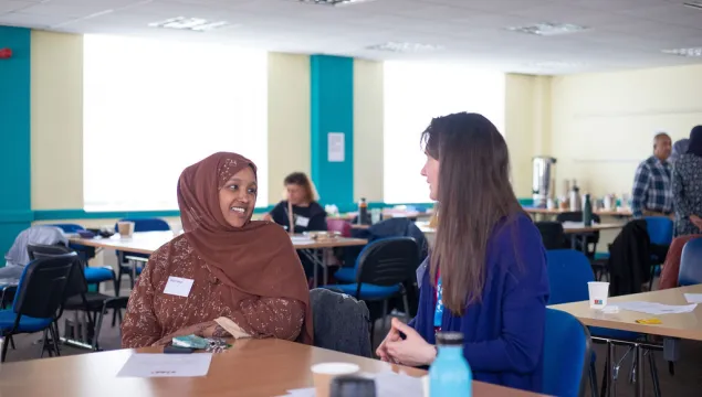 Two people smiling and having a conversation