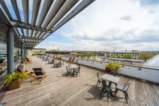 A view of the outside terrace with deck chairs and tables placed throughout