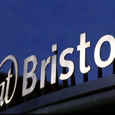 Silver signage reading 'At-Bristol' set against a blue sky. 2010. 