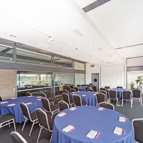 A room filled with round tables and chairs placed around them