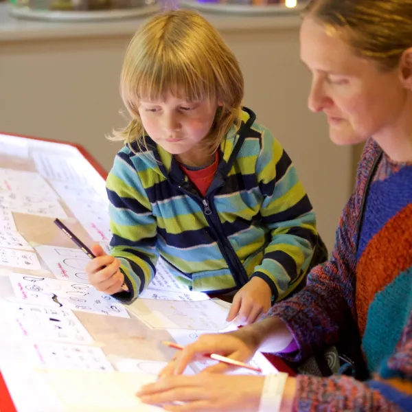 Mother and a child drawing an animation on the lighting box