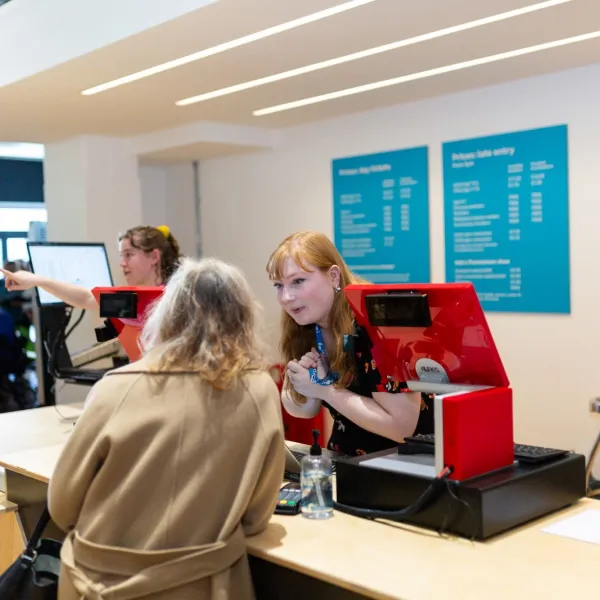 A member of We The Curious staff talks to a visitor at the Welcome Desk