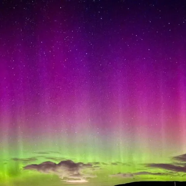Aurora Borealis sky in a purple colour fading to a light green.