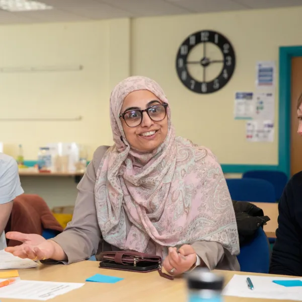 Three women at a table with post it notes and pens