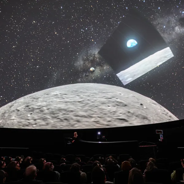 In the Planetarium at We The Curious with people in the audience looking up at the Moon and the image of 'Earthrise' the precursor to the Artemis 2 mission's 'Earthset'.